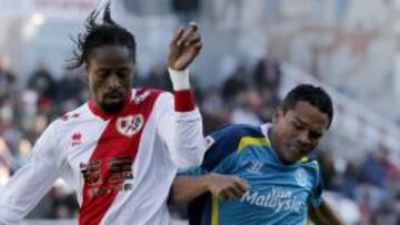 El colombiano del Sevilla Bacca,d, y Abdoulaye Ba ,iz, del Rayo Vallecano, durante el partido de la decimocuarta jornada de la Liga de Primera División que ambos partidos disputaron esta mañana en el estadio de Vallecas (Madrid).