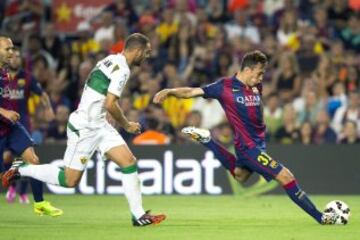 El centrocampista del Barcelona Munir El Haddadi Mohamed (d) disputa un balón con el defensa del Elche David Lombán (i), durante el partido de la primera jornada de la Liga de Primera División, que se juega hoy en el Camp Nou.