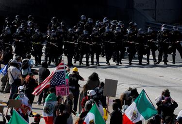 La policía se enfrenta a manifestantes durante una protesta contra las redadas federales de inmigración en el centro de Los Ángeles.