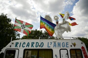 Un aficionado disfradado de ángel presente en la etapa, anima encima de su furgoneta.