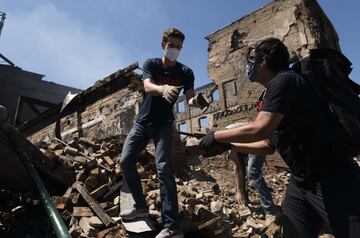 MINNEAPOLIS, MN - MAY 30: People work to clean up outside a burned building on May 30, 2020 in Minneapolis, Minnesota. Buildings and businesses around the Twin Cities have been looted and destroyed in the fallout after the death of George Floyd while in police custody. Police Officer Derek Chauvin has been charged with third-degree murder and manslaughter in Floyd's death. Stephen Maturen/Getty Images/AFP == FOR NEWSPAPERS, INTERNET, TELCOS & TELEVISION USE ONLY ==