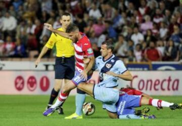 El delantero del Granada Alfredo Ortuño (i) disputa un balón con el defensa del Rayo Vallecano Antonio Amaya.