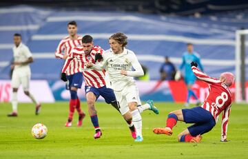 Luka Modric en carrera con la oposición de Rdorigo de Paul y antoine Griezmann cayendo al césped.