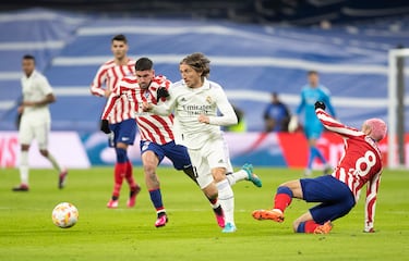 Luka Modric en carrera con la oposición de Rdorigo de Paul y antoine Griezmann cayendo al césped.
