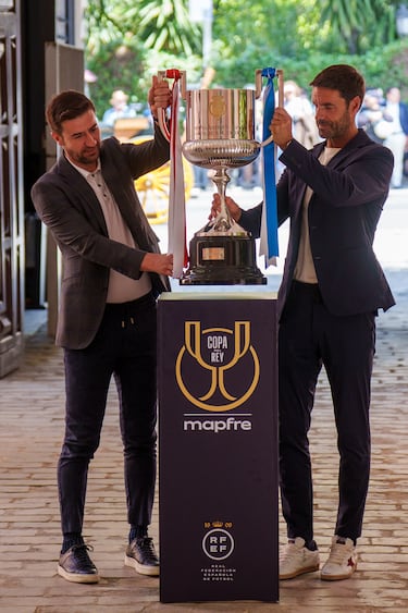 El excapitán del Atlético de Madrid, Gabi (i), junto al excentrocampista de la Real Sociedad, Xabi Prieto (d), portan la Copa del Rey a su llegada a Sevilla. 