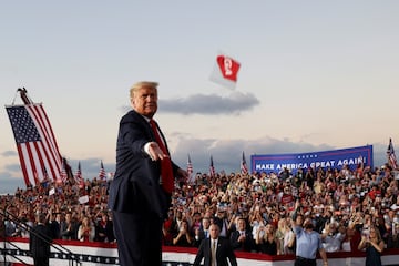 Donald Trump es captado lanzando una mascarilla durante un mitin de campaña en octubre de 2020, cuando el índice de casos de covid-19 aún era alto.