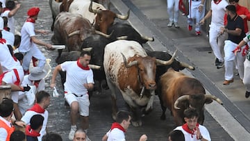 Participants run ahead of La Palmosilla breed bulls during the seventh running of the bulls of the San Fermin festival in Pamplona, northern Spain, on July 13, 2025. Thousands of people every year attend the week-long festival and its famous "encierros" or bull runs, every day at 8:00 a.m. through the narrow streets of the old town over an 850 meters (yard) course while runners ahead of them try to stay close to the bulls without falling over or being gored. (Photo by MIGUEL RIOPA / AFP)