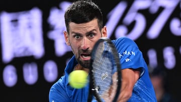 Serbia's Novak Djokovic hits a return against Spain's Carlos Alcaraz during their men's singles quarterfinal match on day ten of the Australian Open tennis tournament in Melbourne on January 22, 2025. (Photo by WILLIAM WEST / AFP) / -- IMAGE RESTRICTED TO EDITORIAL USE - STRICTLY NO COMMERCIAL USE --