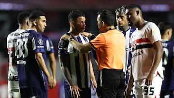 Miguel Navarro, de Talleres, habla con el árbitro Piero Daniel Maza Gómez.