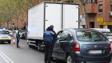 Dos policías municipales le piden la documentación a los conductores de dos vehículos, uno de ellos un particular y otro un camión, en un control de policial en el municipio madrileño de Vallecas para vigilar que todos aquellos que se salen durante el con