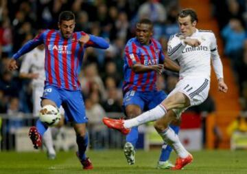 El centrocampista galés del Real Madrid Gareth Bale dispara ante los jugadores del Levante Víctor Camarsa y el mozambiqueño Simao