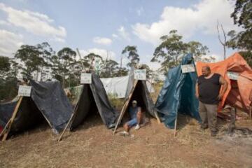 Integrantes del Movimiento de los Trabajadores Sin Techo (MTST) permanecen en sus viviendas improvisadas en una área que fue ocupada el pasado sábado situada a unos 4 kilómetros del estadio Arena Corinthians de Sao Paulo, una de las doce sedes del Mundial Brasil 2014 y que recibirá seis partidos del evento deportivo, entre ellos el inaugural del 12 de junio. De acuerdo con el movimiento, las familias que ocuparon el terreno, abandonado desde hace más de 20 años, vivían en áreas "de riesgo", "en favelas o sin condiciones para pagar el alquiler por culpa de la especulación inmobiliaria en la región, resultado de la construcción del estadio de apertura del Mundial".