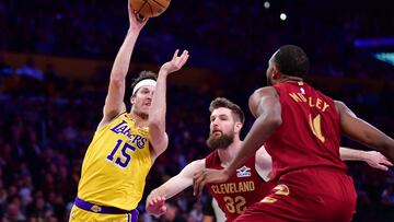 Dec 31, 2024; Los Angeles, California, USA; Los Angeles Lakers guard Austin Reaves (15) passes the ball against Cleveland Cavaliers forward Dean Wade (32) and guard Donovan Mitchell (45) during the first half at Crypto.com Arena. Mandatory Credit: Gary A. Vasquez-Imagn Images