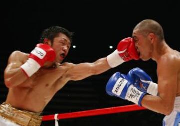 El campeón defensor Akira Yaegashi golpea al retador Oscar Blanquet de México en la cara durante el combate de boxeo peso mosca por el título mundial en Tokio 12 de agosto 2013.