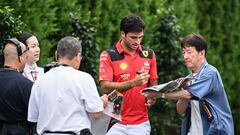 Ferrari's Spanish driver Carlos Sainz Jr (2nd R) signs autographs as he arrives ahead of the third practice session for the Formula One Japanese Grand Prix at the Suzuka circuit, Mie prefecture on September 23, 2023. (Photo by Peter PARKS / AFP)