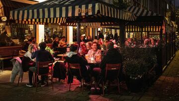 Consumers on a terrace of a cafe - restaurant enjoy their last drink before all catering have to close their doors at seven o'clock in Amsterdam, on November 13, 2021 as the cabinet has tightened the coronavirus measures again due to rising contamination figures. (Photo by Ramon van Flymen / ANP / AFP) / Netherlands OUT