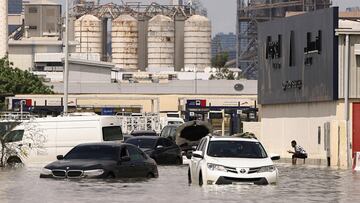 A person sits near vehicles stranded in flood water caused by heavy rains in Dubai, United Arab Emirates, April 17, 2024. REUTERS/Amr Alfiky