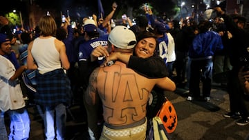 A person embraces a Dodgers fan showing his LA Dodgers logo tattooed on his body during celebrations on the street after the Los Angeles Dodgers' victory over the New York Yankees to win the World Series in Los Angeles.