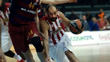 Olympiacos Piraeus&#039; Vassilis Spanoulis (R) vies with Barcelona&#039;s Ante Tomic (L) during the Euroleague Top 16 group F basketball match between Olympiacos Piraeus and Barcelona at the Peace and Friendship stadium in the Piraeus district of Athens on December 29, 2015. / AFP / ANGELOS TZORTZINIS