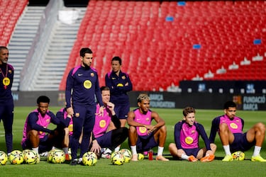 Los jugadores del FC Barcelona atienden al entrenador mientras les explica los siguientes ejercicios.