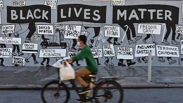 A person on a bike rides past a "Black Lives Matter" mural at Union Square on June 12, 2020 in New York City. - Demonstrations are being held across the US following the death of George Floyd on May 25, 2020, while being arrested in Minneapolis,