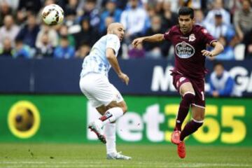 El defensa del Deportivo Juanfran Moreno despeja el balón ante el delantero neerlandés-marroquí del Málaga Nordin Amrabat