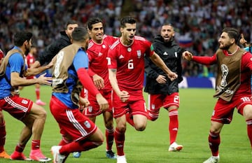 Iran's Saeid Ezatolahi celebrates scoring their first goal with team mates before it was disallowed after a VAR review.