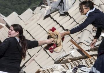 ITA88 AMATRICE (ITALIA) 24/08/2016.- Dos mujeres sostienen un peluche en Amatrice, en el centro de Italia, hoy, 24 de agosto de 2016. Al menos 38 personas han muerto y decenas se encuentran desaparecidas a causa del terremoto de 6,0 grados de magnitud en la escala abierta de Richter que ha sacudido el centro de Italia en la madrugada de hoy, informó la Protección Civil italiana. EFE/Massimo Percossi