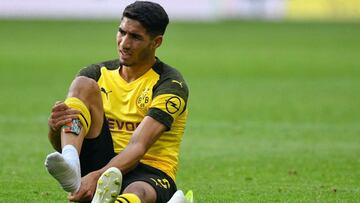 Dortmund's defender Achraf Hakimi takes off his shoe after beeing injured during the German first division Bundesliga football match Borussia Dortmund v VfL Wolfsburg on March 30, 2019 in Dortmund. (Photo by SASCHA SCHUERMANN / AFP) / RESTRICTIONS: D