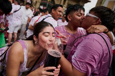 Una asistente al "Chupinazo" bebe vino durante la fiesta ininterrumpida en el famoso festival de encierros de toros de Pamplona.