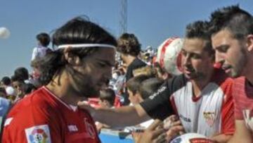<b>A PUNTO. </b>Sergio Sánchez, firmando balones a varios aficionados sevillistas.