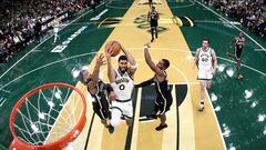 Jayson Tatum #0 of the Boston Celtics takes a shot between Trendon Watford #9 and Lonnie Walker IV #8 of the Brooklyn Nets