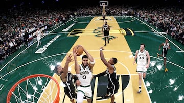 Jayson Tatum #0 of the Boston Celtics takes a shot between Trendon Watford #9 and Lonnie Walker IV #8 of the Brooklyn Nets