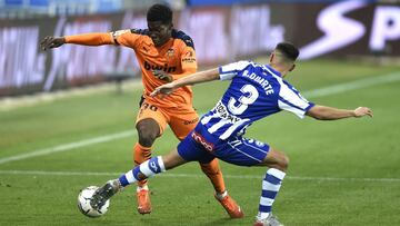 VITORIA-GASTEIZ, SPAIN - NOVEMBER 22: Yunus Musah of Valencia battles for possession with Ruben Duarte of Deportivo Alaves during the La Liga Santander match between Alaves and Valencia on November 22, 2020 in Vitoria-Gasteiz, Spain. Sporting stadiums aro