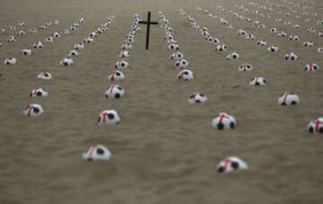 Miembros de la ONG Río de Paz colocan balones de fútbol marcados con cruces rojas como protesta en la playa de Copacabana en Río de Janeiro. La protesta fue un llamado al gobierno para que los servicios de educación, salud pública y para lograr los mismos estándares que los estadios de la Copa Mundial de la FIFA, de acuerdo con la Organización.