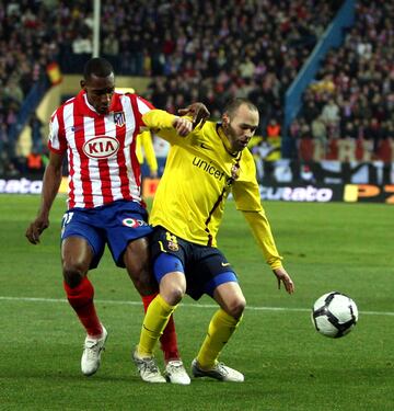 El jugador del Barcelona Iniesta trata de controlar el bal¨®n ante el jugador del Atl¨¦tico Perea.