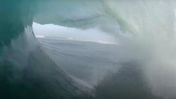 Imagen captada por un dron del interior de un tubo de la ola m&aacute;s grande del mundo, en Nazar&eacute; (Portugal). Rodeado de agua y al fondo, se ven olas. 