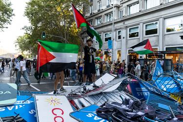 Manifestantes pro-palestina sostienen banderas palestinas sobre una barricada de vallas después de que varios manifestantes invadieran el circuito de la última etapa de La Vuelta en el centro de Madrid, España, en una protesta contra la participación del equipo israelí Premier Tech el 14 de septiembre de 2025.