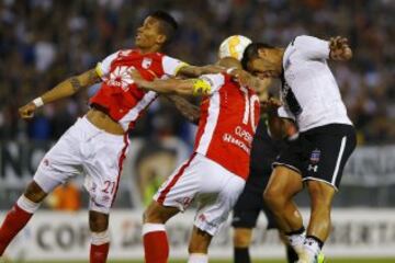 Jose Caceres (R) of Chile's Colo Colo heads a ball next to Omar Perez (C) and Francisco Meza (L) of Colombia's Independiente Santa Fe during their Copa Libertadores soccer match in Santiago, April 15, 2015. REUTERS/Ivan Alvarado