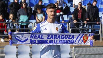 Javi Puado posa con una bufanda del Real Zaragoza en su presentaci&oacute;n en La Romareda.