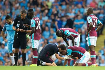 Reid (second right) is treated after clashing with Agüero.