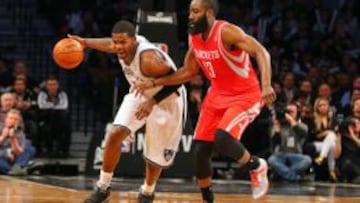 Joe Johnson (7) de los Net lleva la bola ante James Harden (13).