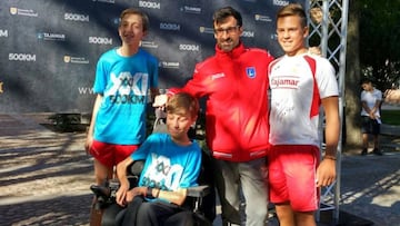 Chuso García Bragado posa con unos chavales a su llegada al Colegio Tajamar, que le hizo entrega de la medalla de oro por su trayectoria deportiva.