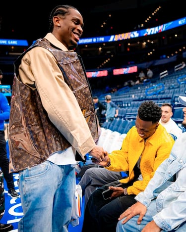 El delantero brasileño del Real Madrid, Vinicius, y el base del equipo de la NBA, Oklahoma City Thunder, Shai Gilgeous-Alexander, se saludan antes del inicio del partido. 