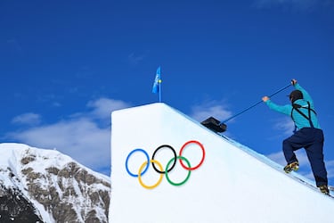 Un miembro del equipo de tierra prepara el escenario antes de la primera manga de clasificación de esquí acrobático masculino de "slopestyle".