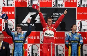 Ferrari Formula One driver Michael Schumacher of Germany (C) poses with second placed Renault driver Fernando Alonso of Spain (L) and third placed Renault driver Giancarlo Fisichella of Italy after the China Grand Prix at the Shanghai International Circuit October 1, 2006. Schumacher won the Chinese Grand Prix on Sunday to move level on points with Alonso in the world championship with two races remaining in the season.   REUTERS/Nir Elias  (CHINA)