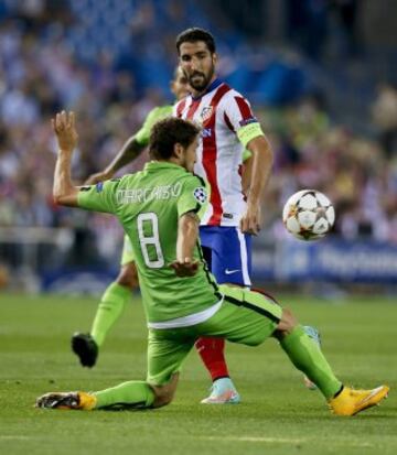 El delantero del Atlético de Madrid Raúl García (d) lucha el balón con Claudio Marchisio, de la Juventus, durante el partido de la segunda jornada de la fase de grupos de la Liga de Campeones que se disputa esta noche en el estadio Vicente Calderón, en Madrid. 