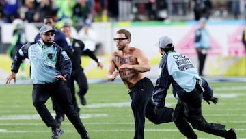 Messages written on the pitch invader’s body sparked online sleuthing and echoed a strikingly similar Super Bowl stunt from 2024.