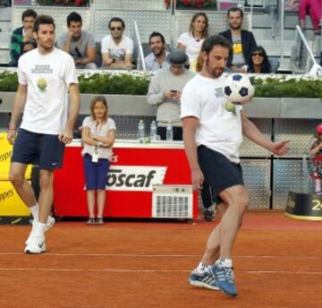 El alero del Real Madrid Rudy Fernández (i) observa al actor Dani Rovira (d) con un balón de fútbol, durante los partidos benéficos del 'Charity Day', previo al Mutua Madrid Open de Tenis 2014 que se inicia este domingo, hoy en la Caja Mágica de Madrid. 