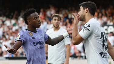 Real Madrid's Brazilian forward Vinicius Junior (L) talks to Valencia's Turkish defender Cenk Ozkacar as he reacts to being insulted from the stands during the Spanish league football match between Valencia CF and Real Madrid CF at the Mestalla stadium in Valencia on May 21, 2023. (Photo by JOSE JORDAN / AFP)